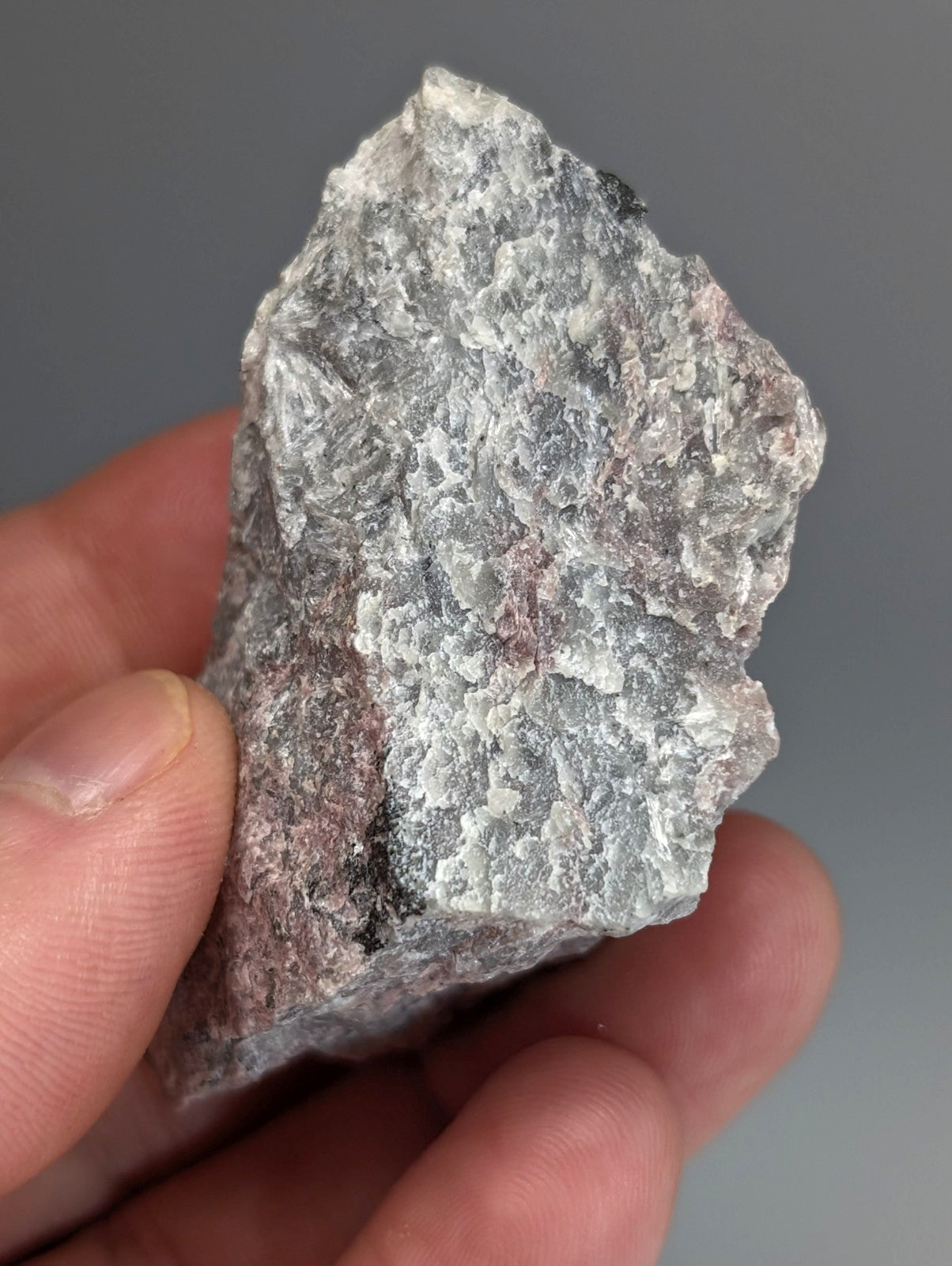A rough very rare miserite and wollastonite rock with mottled gray white and pink hues from wilson springs arkansas