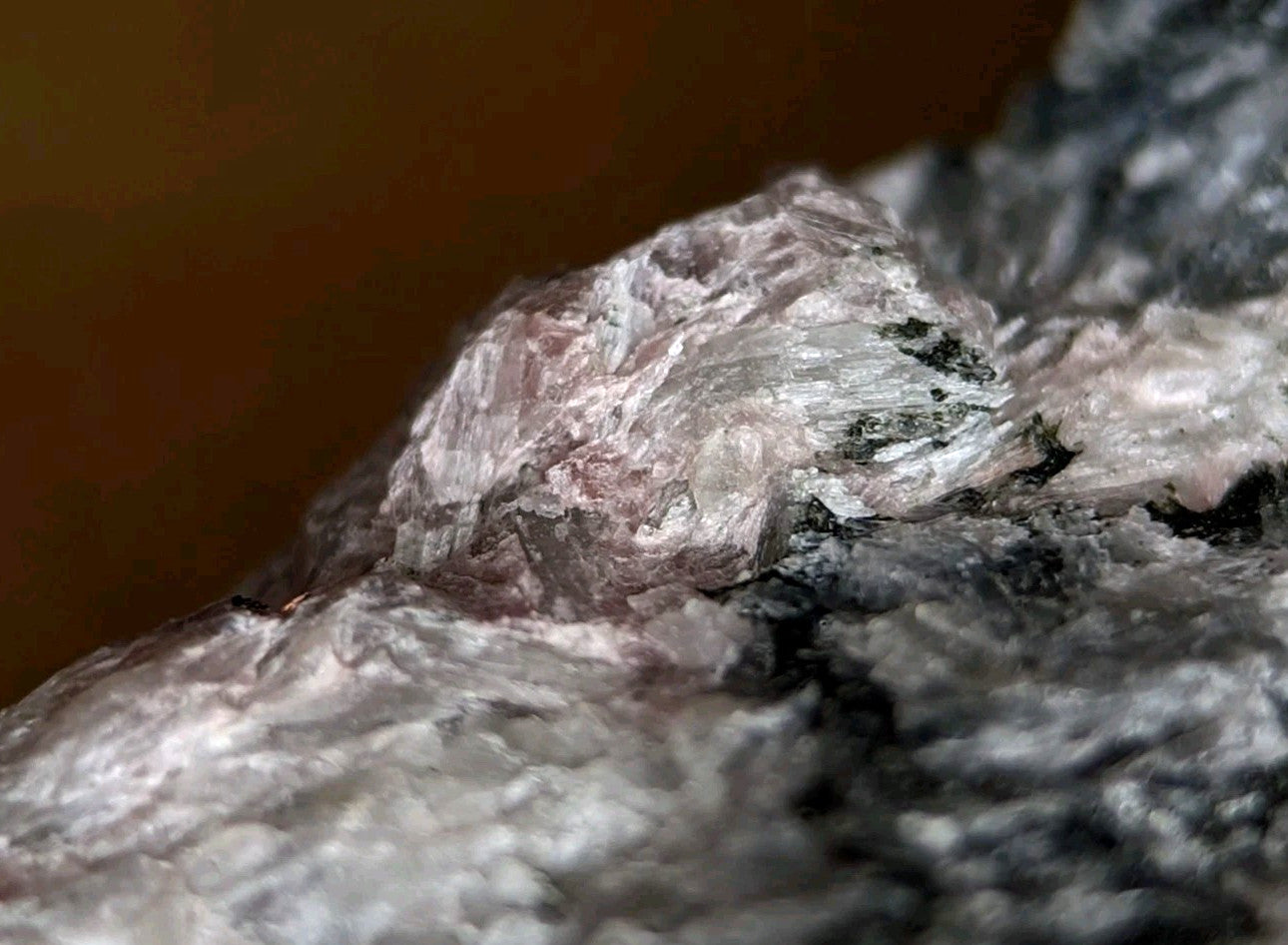 A translucent, crystalline mineral specimen with a pale pinkish hue and jagged edges.