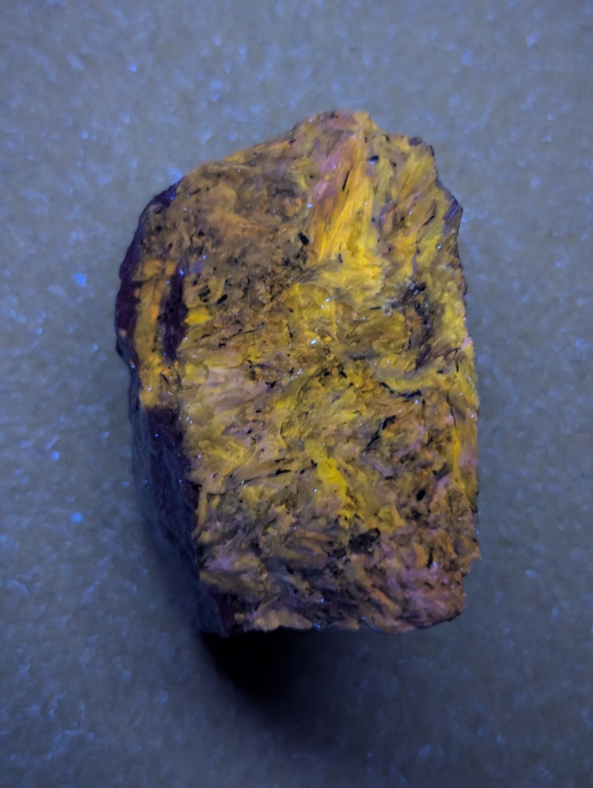 A rough, irregularly shaped piece of golden-yellow and brown mineral with a textured surface.