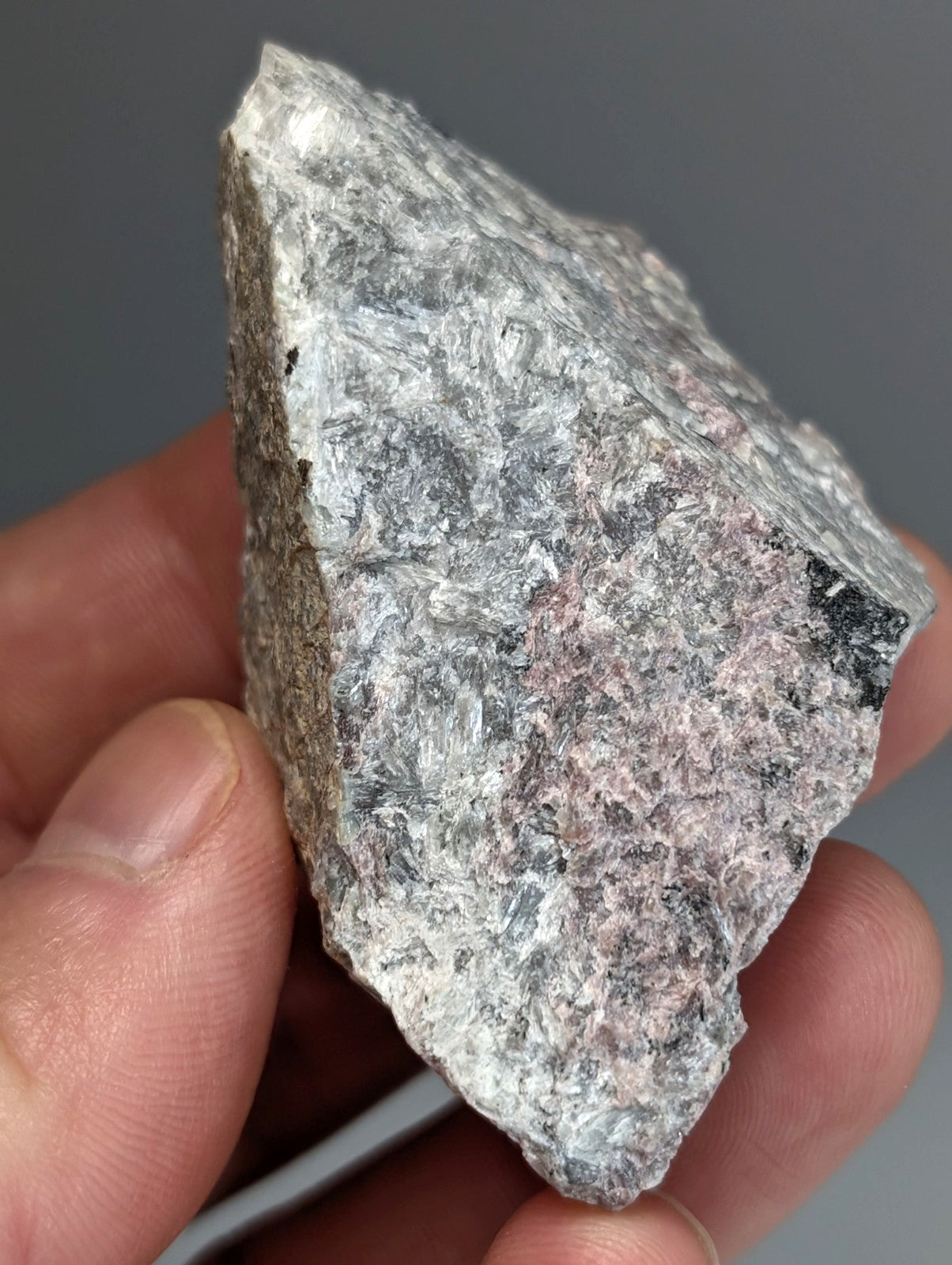 A very rare miserite and wollastonite rock with a rough gray and pinkish mottled surface from arkansas usa