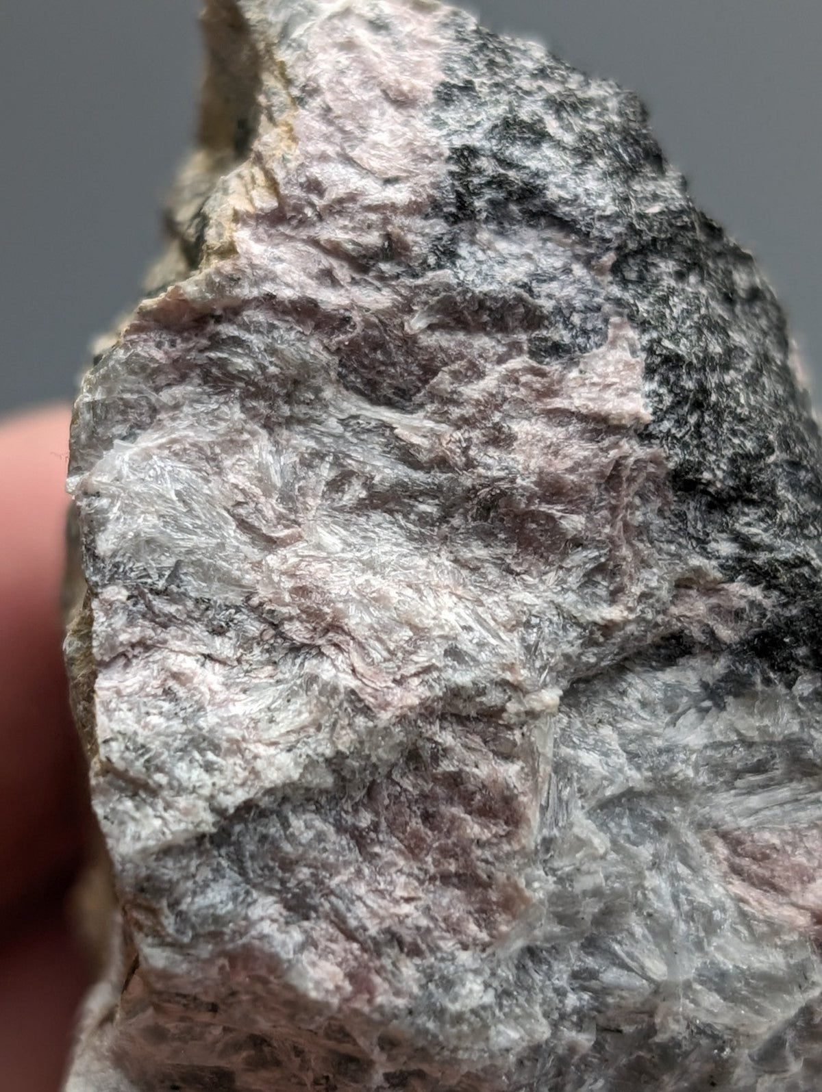 A rough, irregular miserite and wollastonite rock with gray, white, and pink hues from wilson springs arkansas
