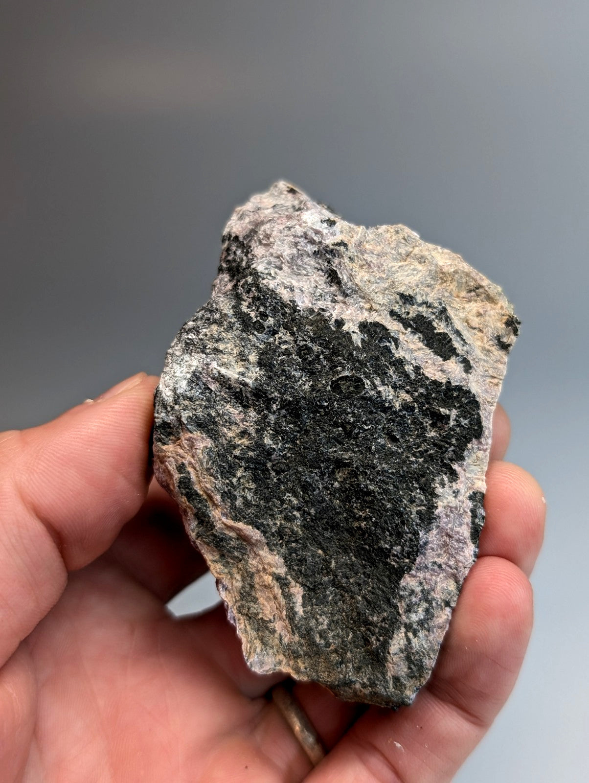 A very rare miserite and wollastonite rock from wilson springs arkansas with dark black gray patches on beige pink tones
