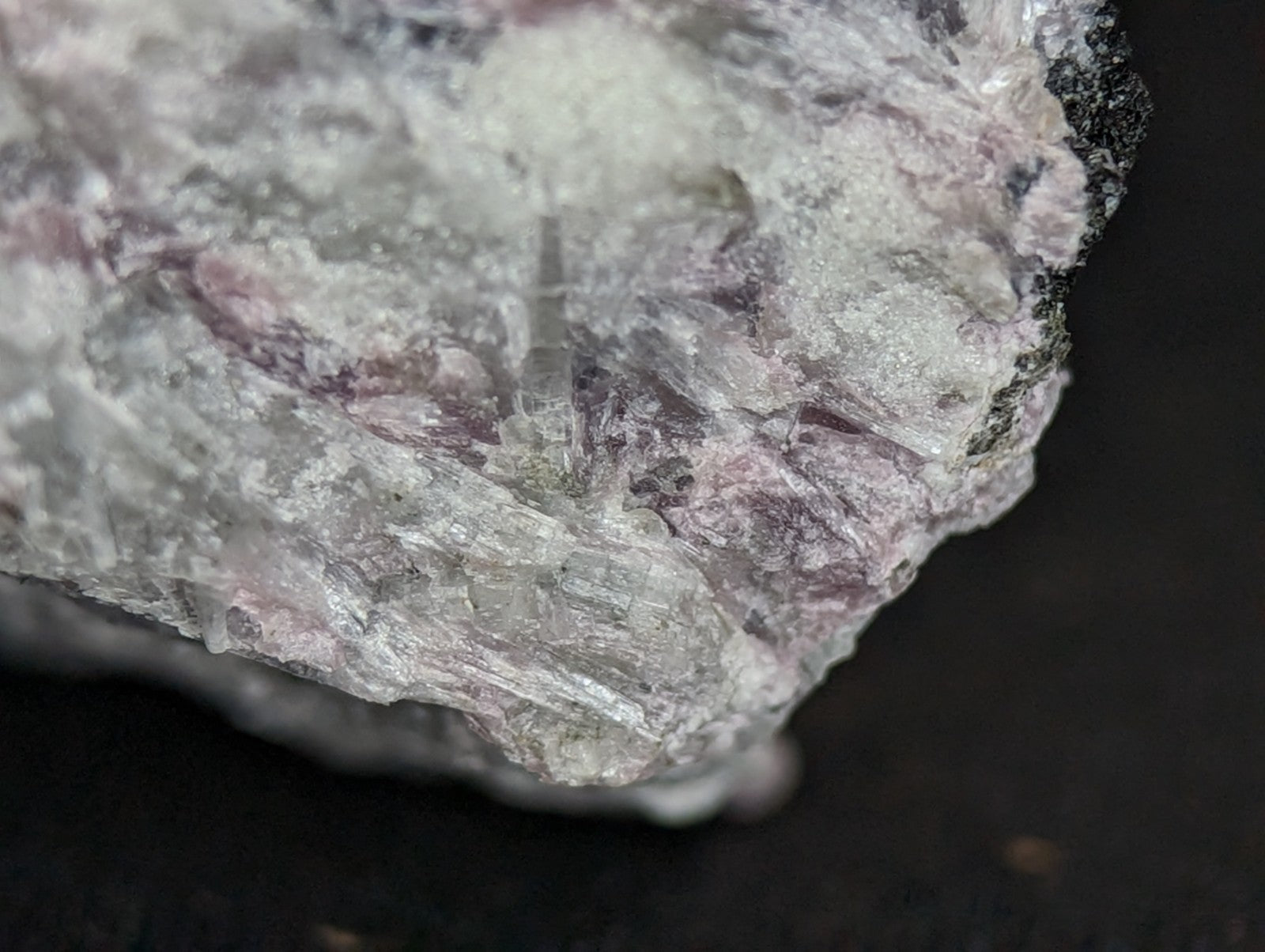 A rough, translucent mineral specimen with a mix of pale lavender and white crystalline textures.