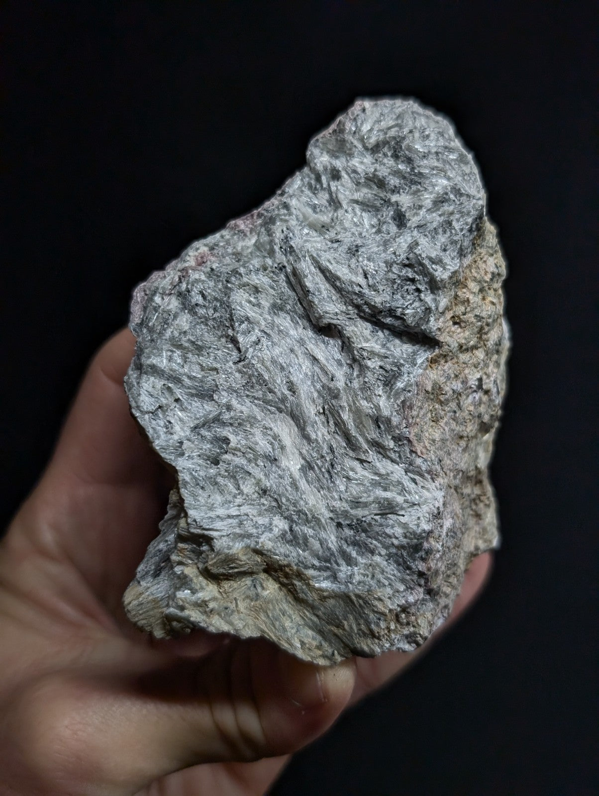A rough, irregularly shaped gray rock with a textured surface and subtle white veining.