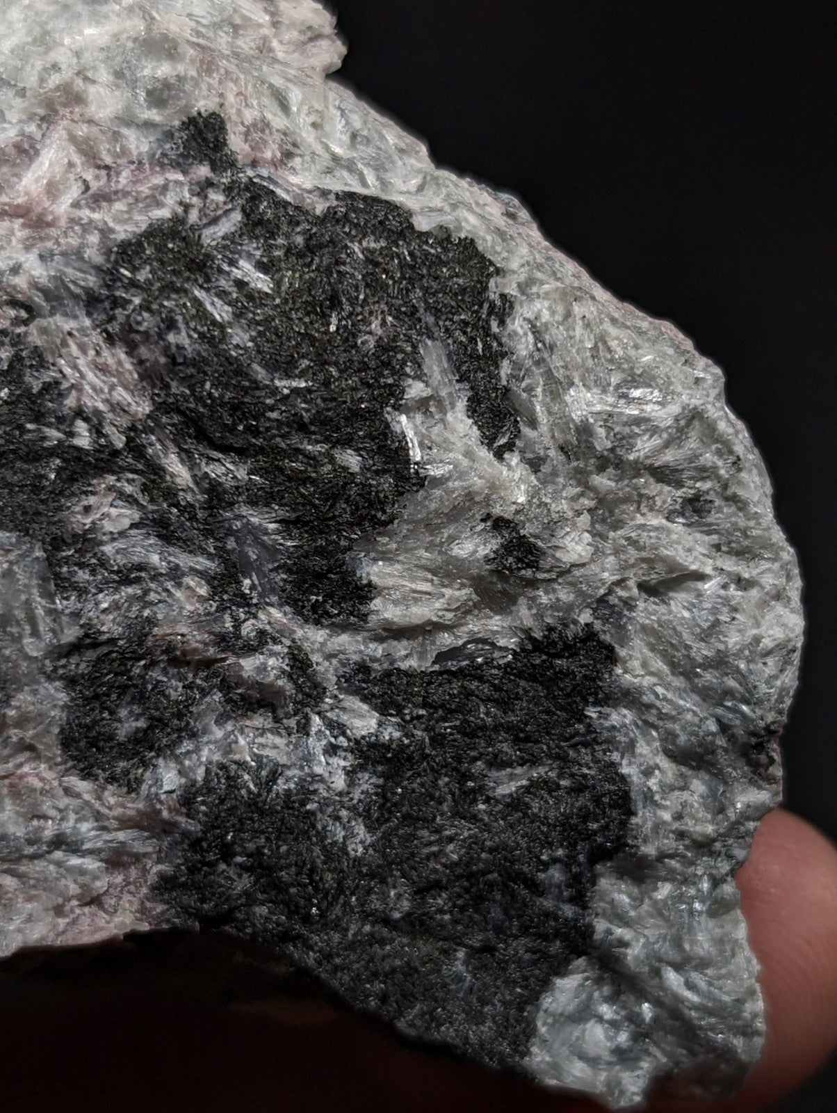 A rugged, naturally occurring mineral specimen featuring a striking contrast between its silvery-gray crystalline matrix and dark black inclusions.