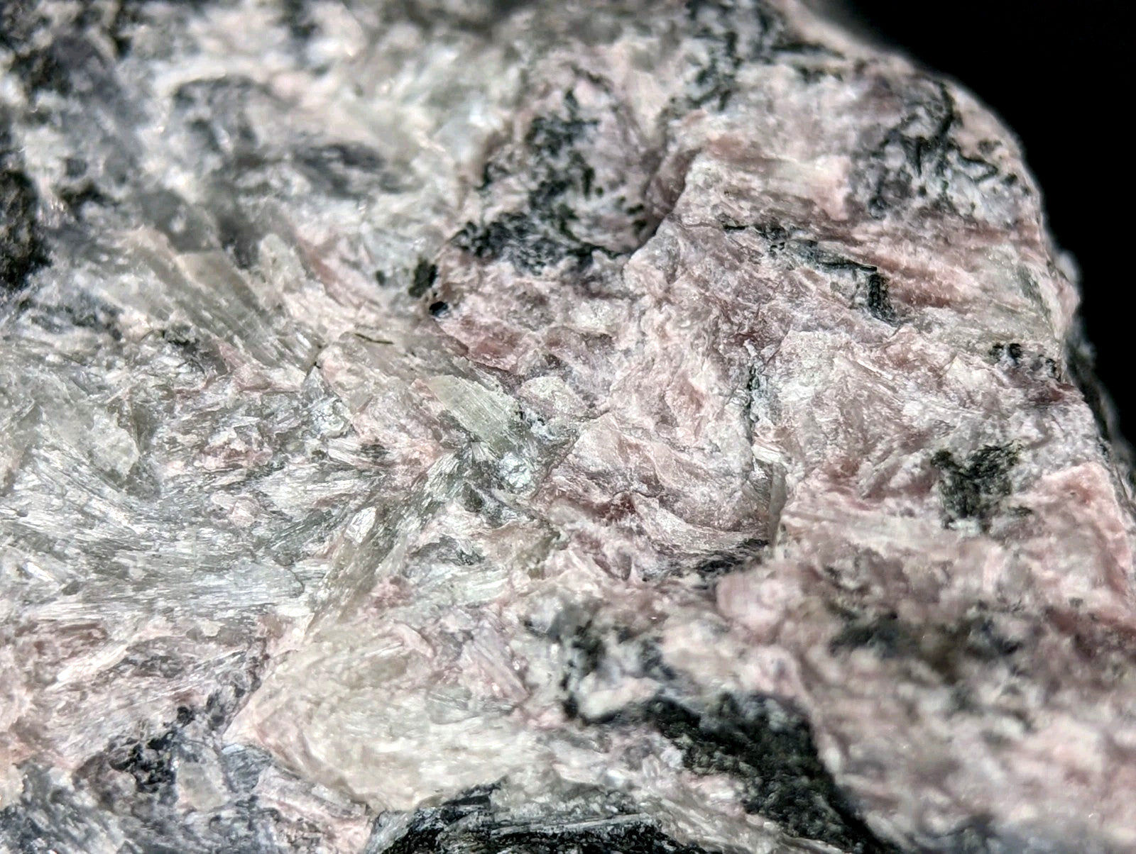 A rough, textured pink and gray granite rock with visible mineral veins.