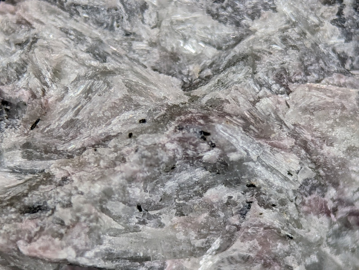 A textured, grayish-white stone with subtle pink and black veining.