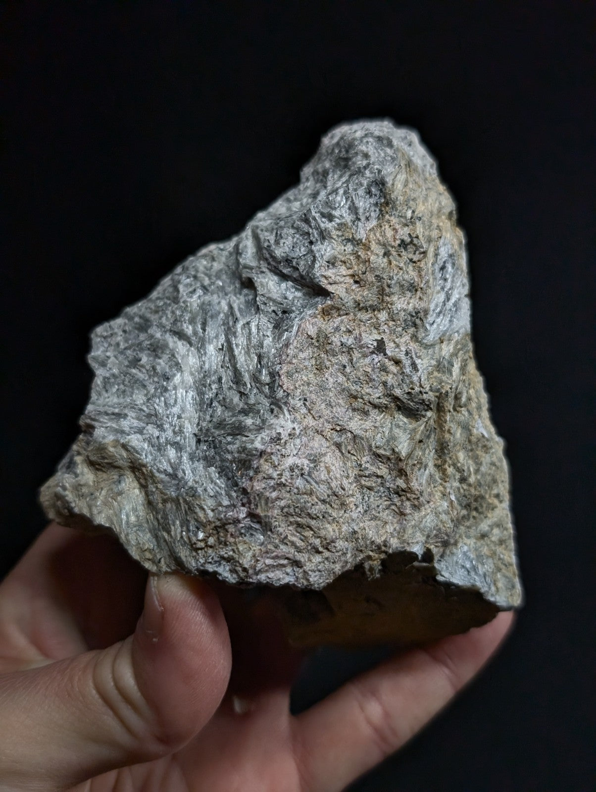 A rough, irregularly shaped gray rock with a textured surface and subtle variations in tone.