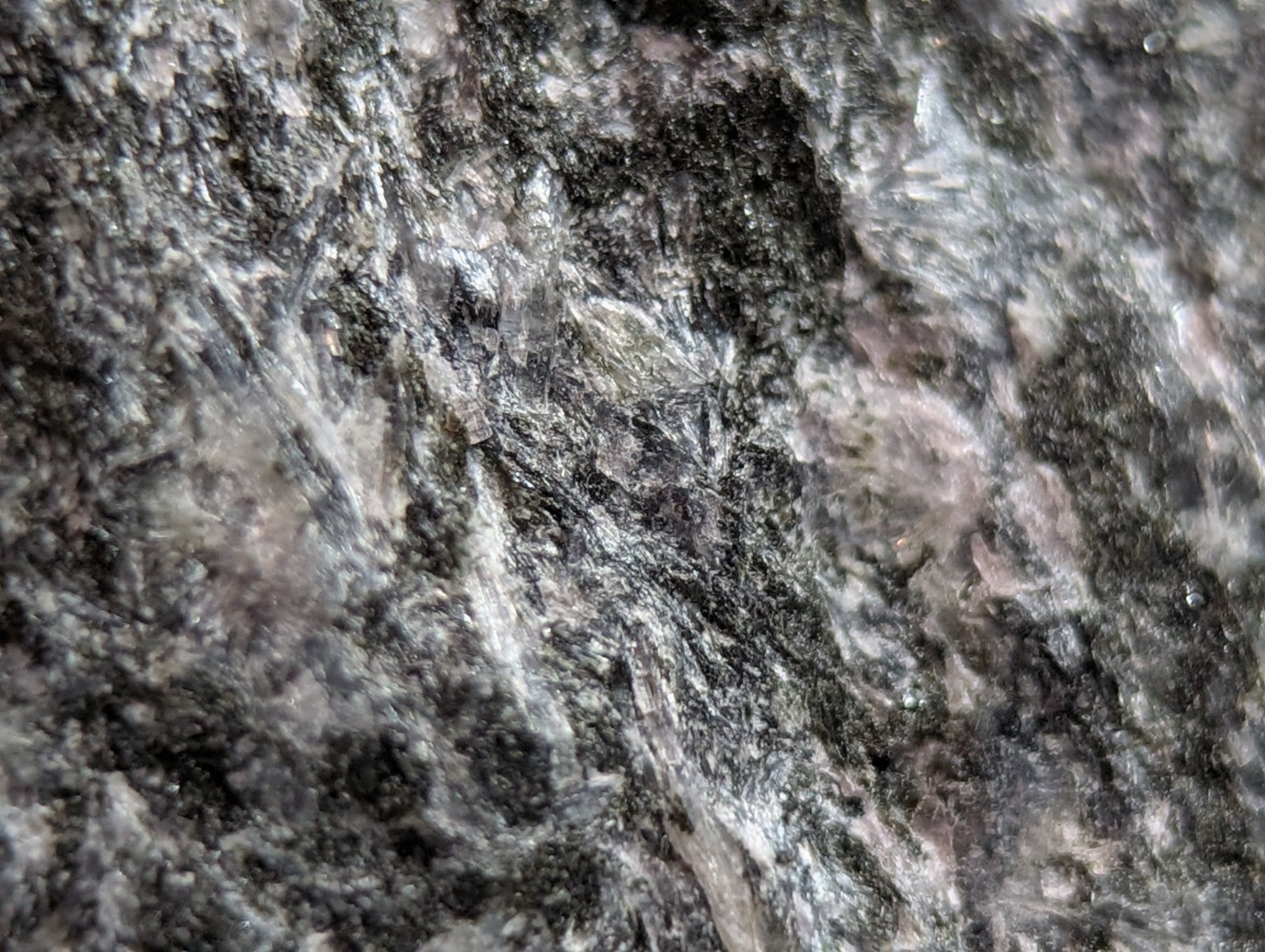 Dark gray granite surface with swirling white and subtle pink veining.