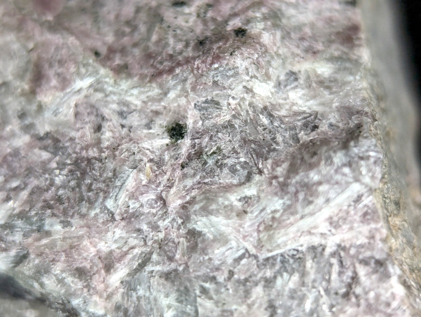 A rough, textured mineral specimen with a mottled pink and gray surface.