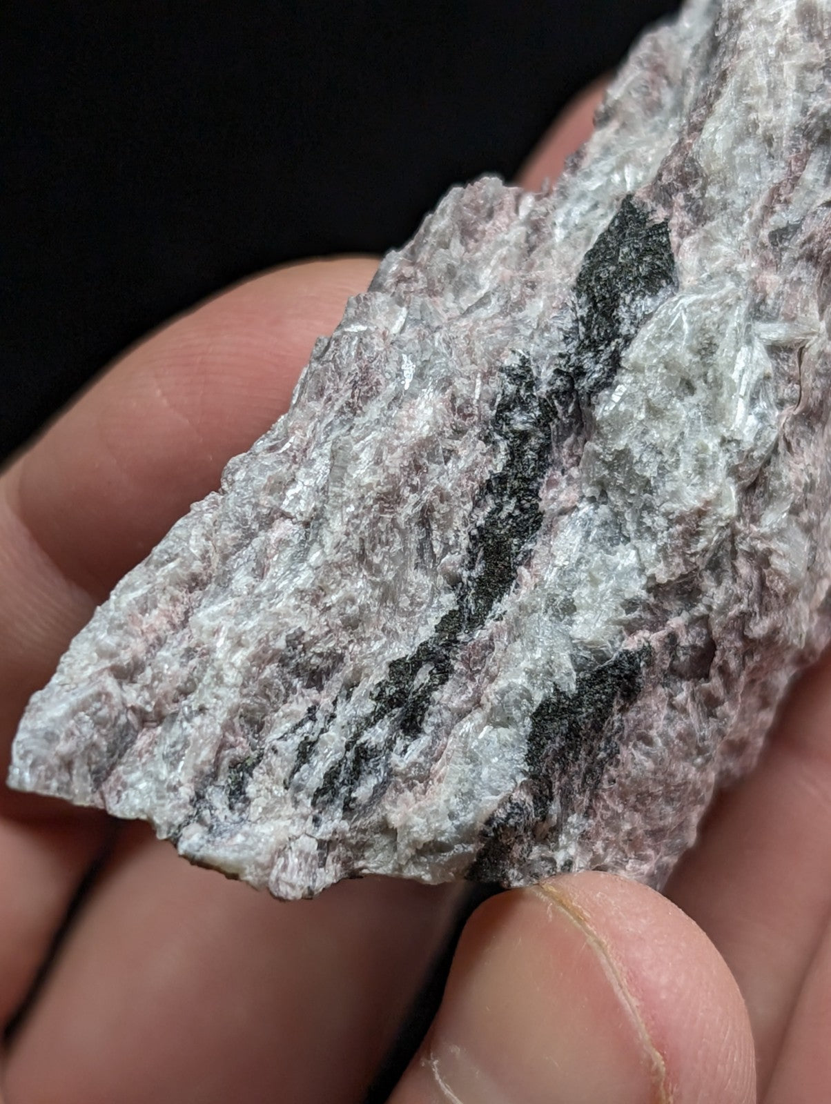 A rough, irregularly shaped mineral specimen with a mottled gray and black surface texture.