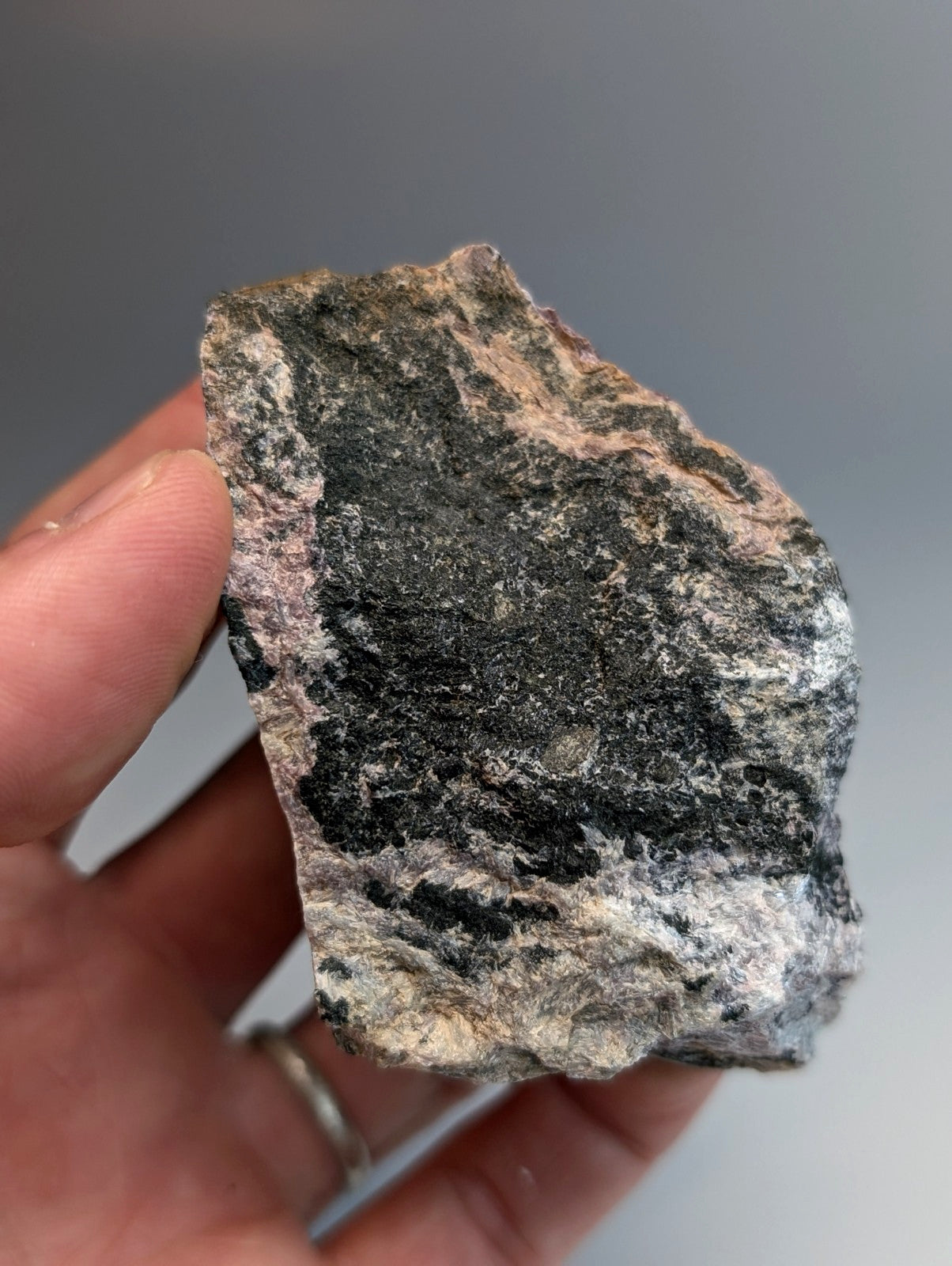 Very rare miserite and wollastonite rock with dark gray black and pinkish-white mineral streaks from arkansas usa