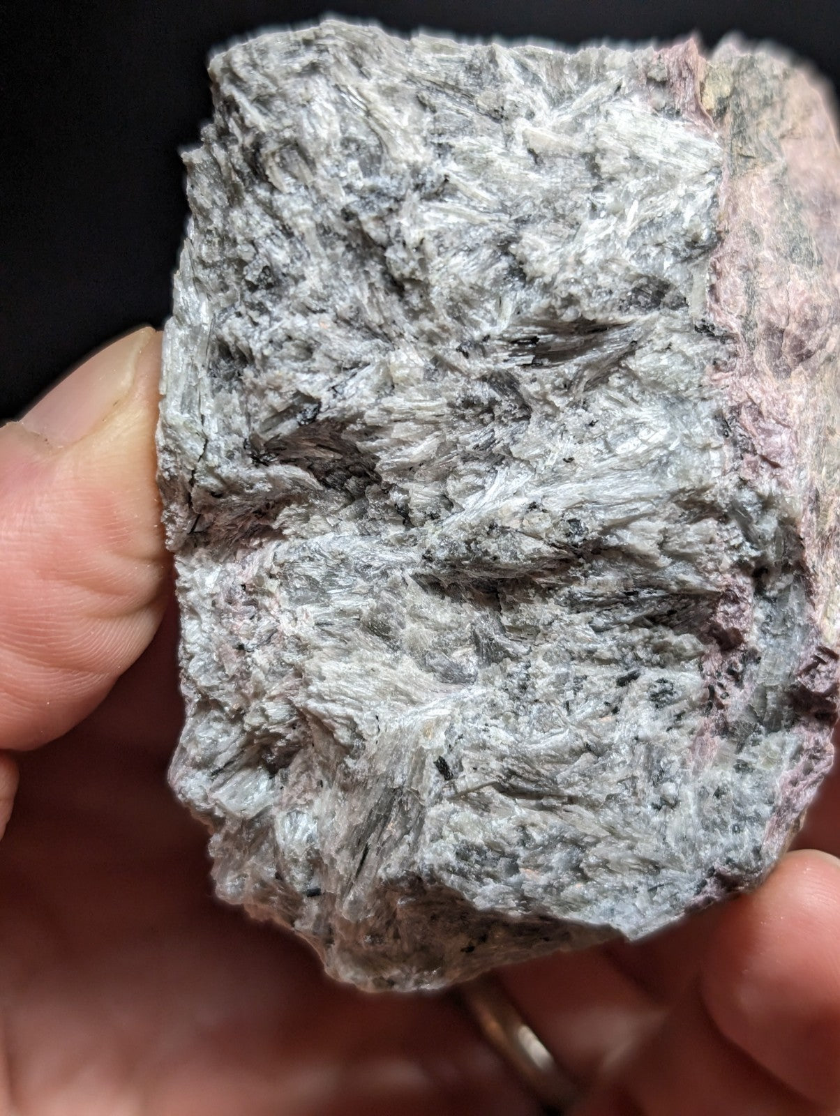 A rough, irregularly shaped rock with a mottled gray and pinkish surface texture.