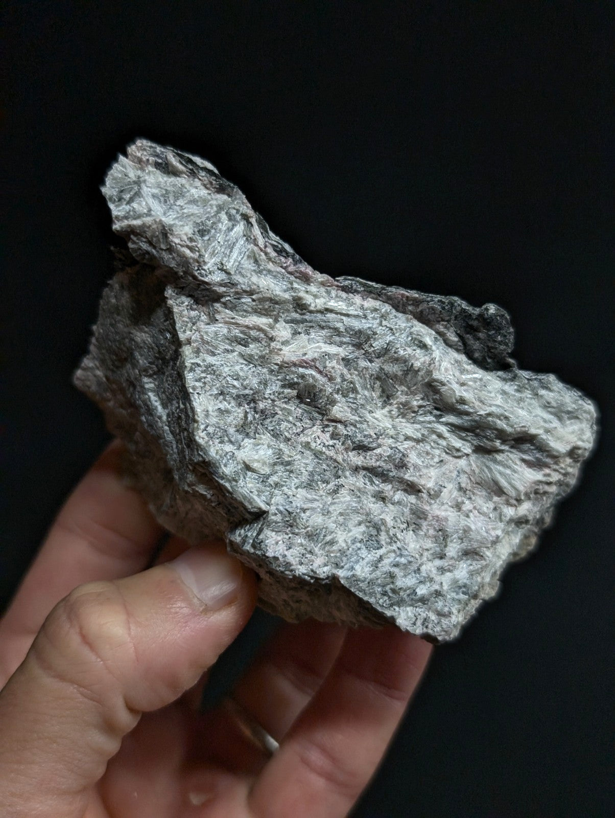 A rough, irregularly shaped gray rock with a mottled texture and visible mineral veins.