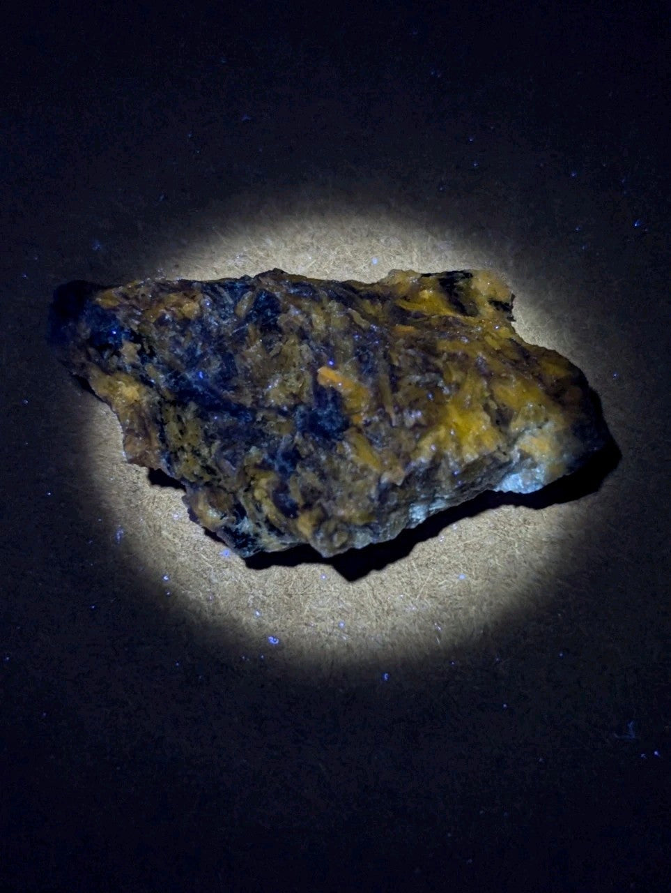 A rugged, irregularly shaped mineral specimen with a mottled surface of deep blue and vibrant yellow patches.