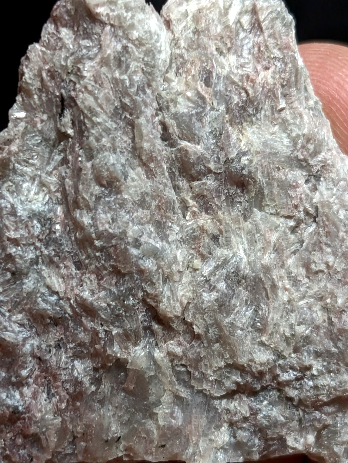 A rough, translucent gray mineral specimen with a crystalline texture and subtle iridescent sheen.