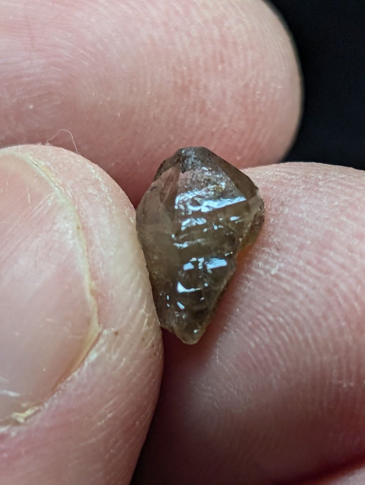A translucent brown crystal with a faceted, angular shape and visible internal inclusions.