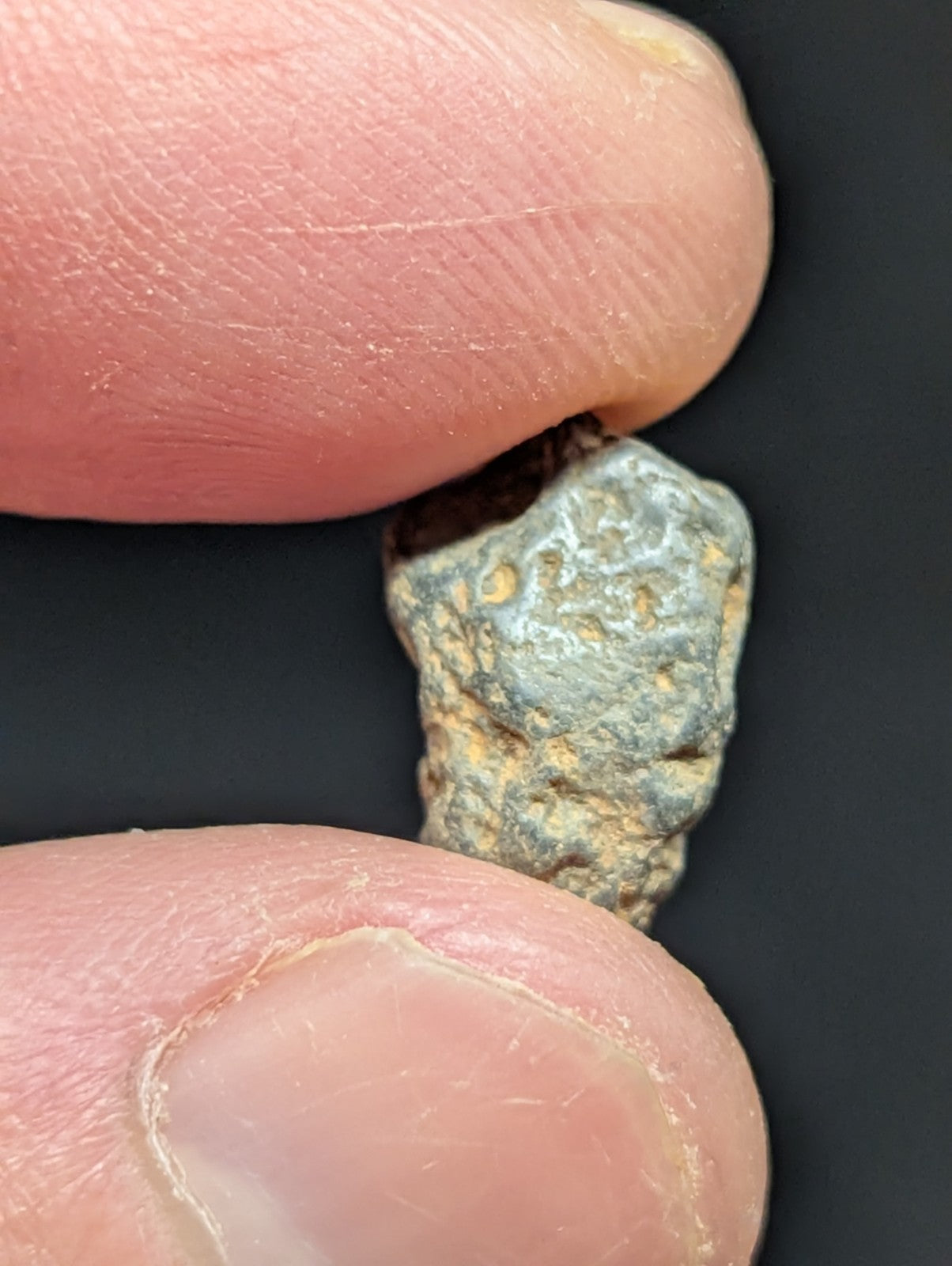 A rough, irregularly shaped mineral specimen with a mottled gray and yellowish surface.