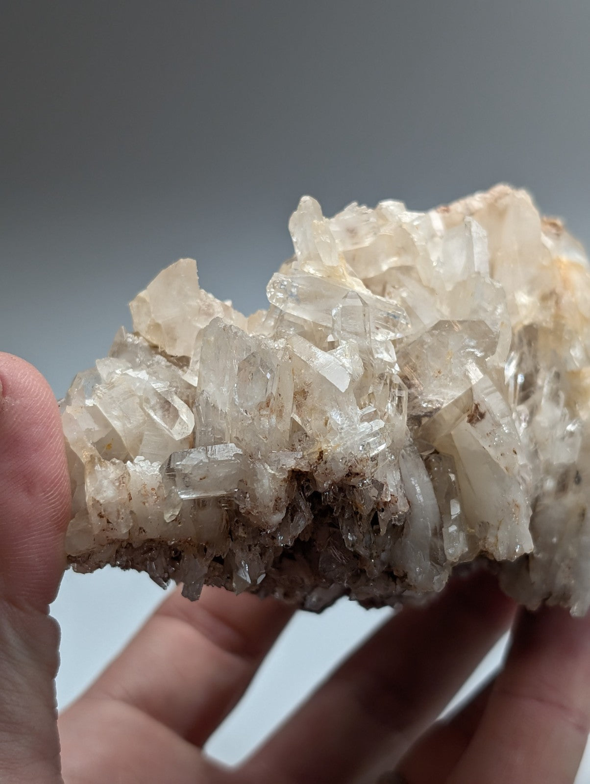 A cluster of translucent clear and faint yellowish faden quartz crystals embedded in a rough matrix from arkansas usa