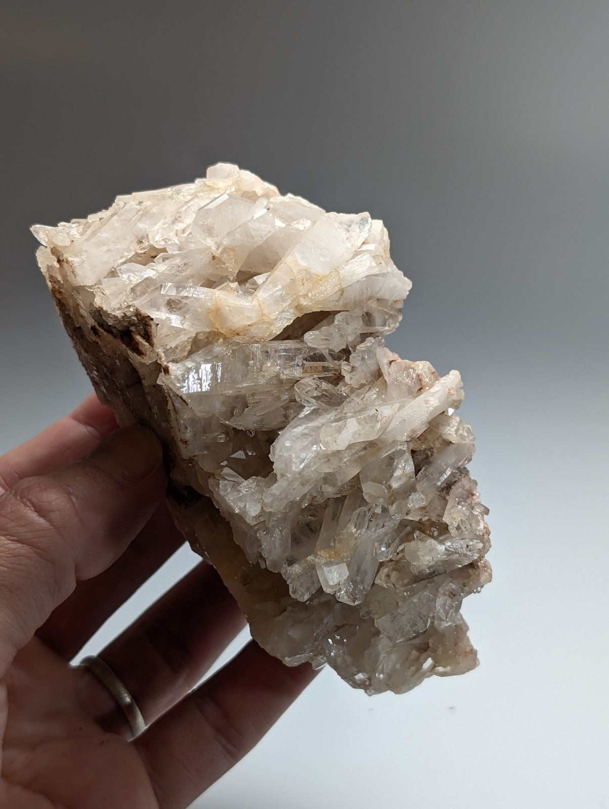A translucent crystalline faden quartz crystal cluster with rough earthy base and sharp faceted formations from Arkansas
