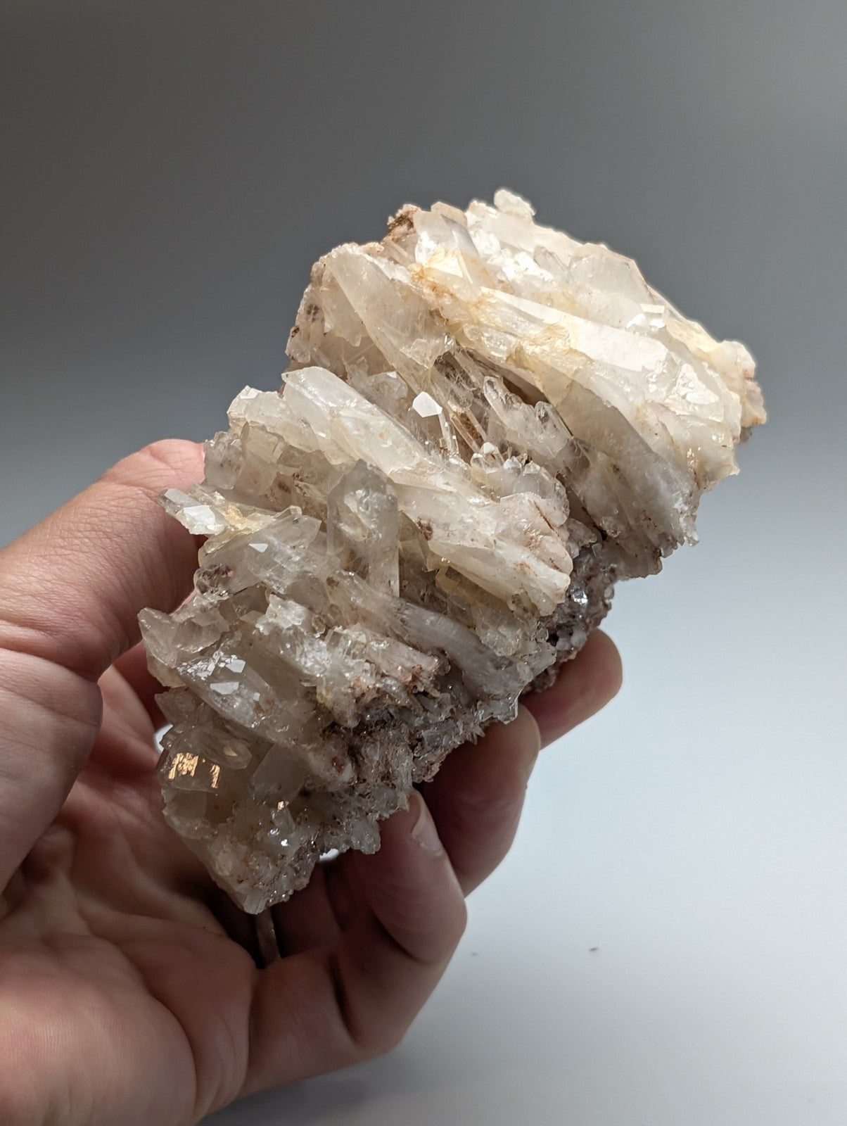 A translucent faden quartz crystal cluster with sharp interlocking facets in clear and milky white hues from Arkansas