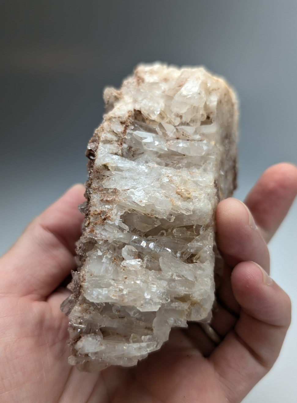 A translucent crystalline quartz cluster with clear facets and rough earthy matrix from montgomery county arkansas usa