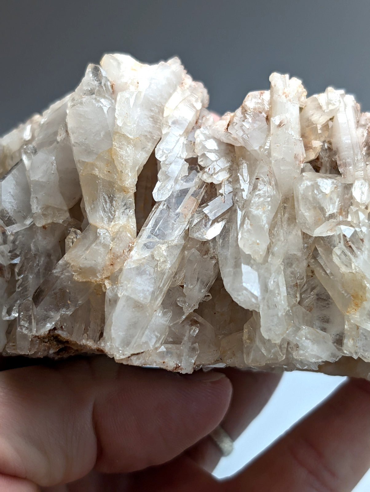 A cluster of translucent clear quartz crystals with subtle yellow tints and sharp faceted edges from montgomery county arkansas