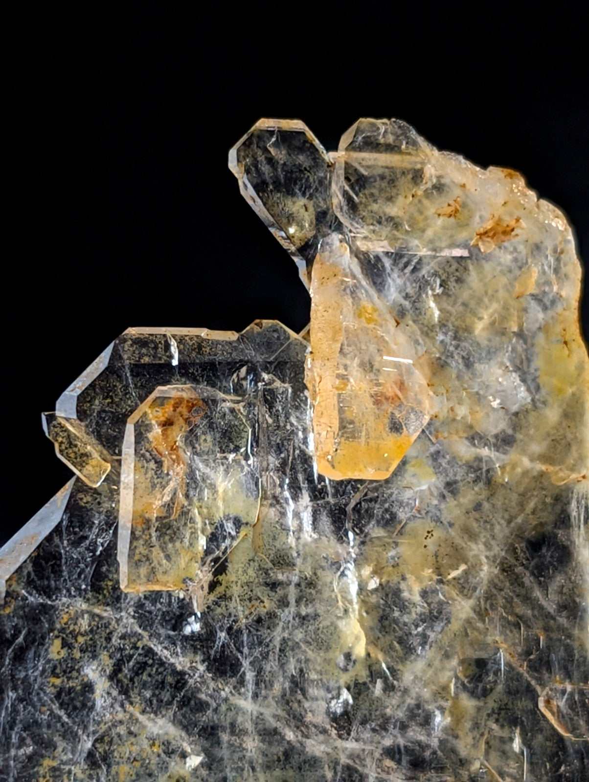 A translucent yellow and clear crystal cluster with intricate, web-like internal patterns.