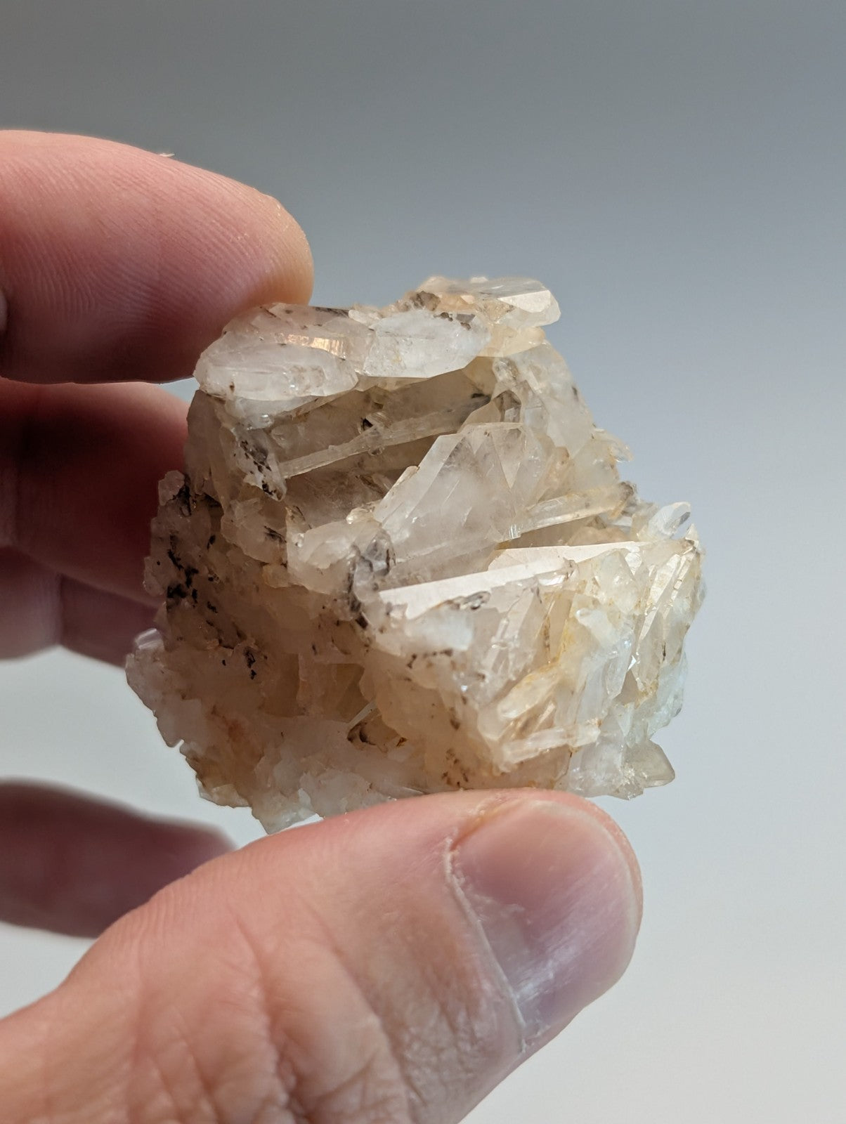 A translucent crystalline quartz specimen with pale yellow crystals and dark inclusions from montgomery county arkansas