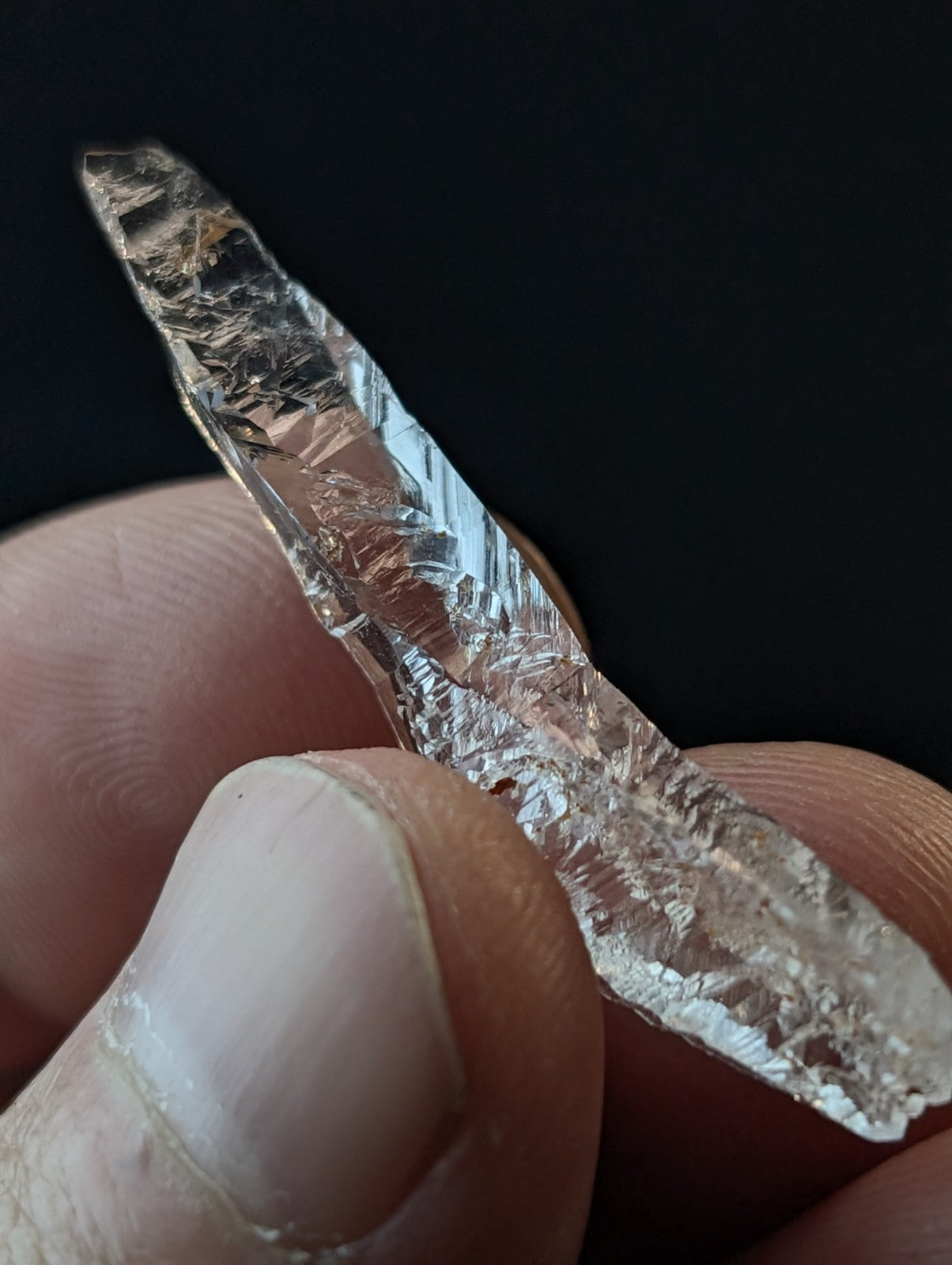 A translucent, jagged-edged raw diamond with a crystalline structure and natural facets.