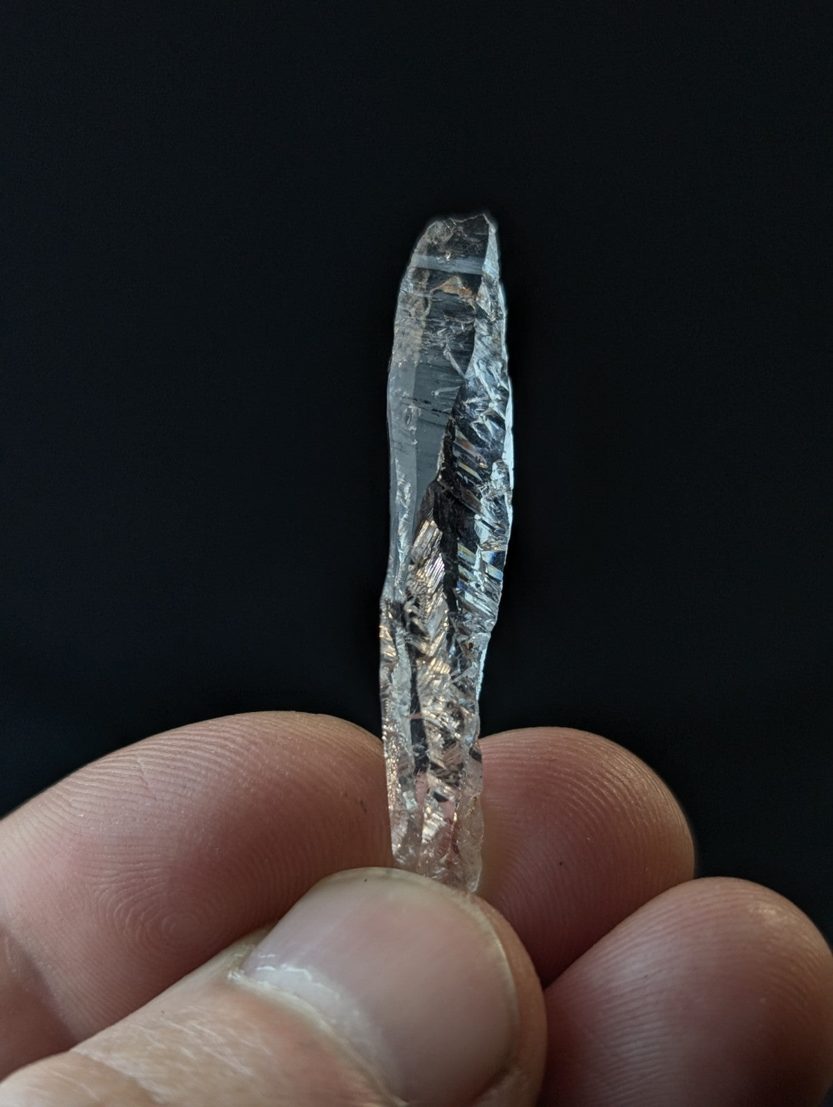 A clear, faceted raw diamond with natural internal inclusions and a translucent appearance.