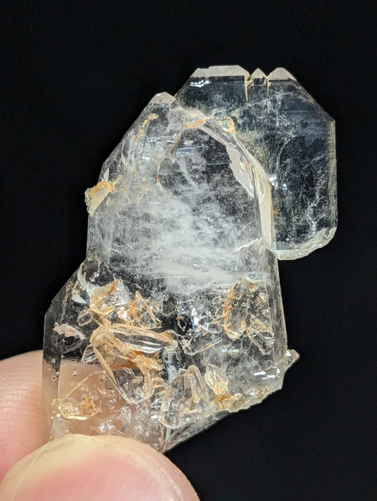 A translucent, clear quartz crystal cluster with intricate internal formations and subtle golden inclusions.