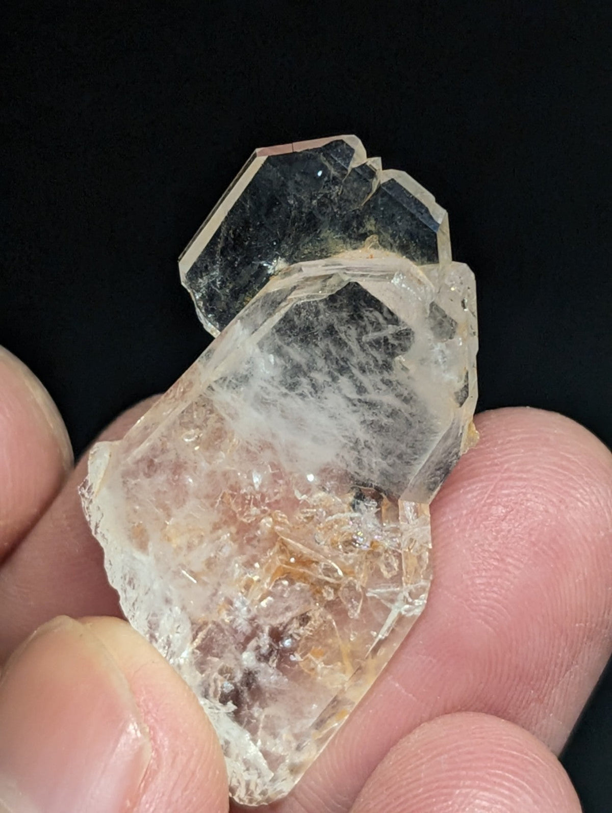 A translucent, faceted quartz crystal cluster with a mix of clear and amber-hued sections.