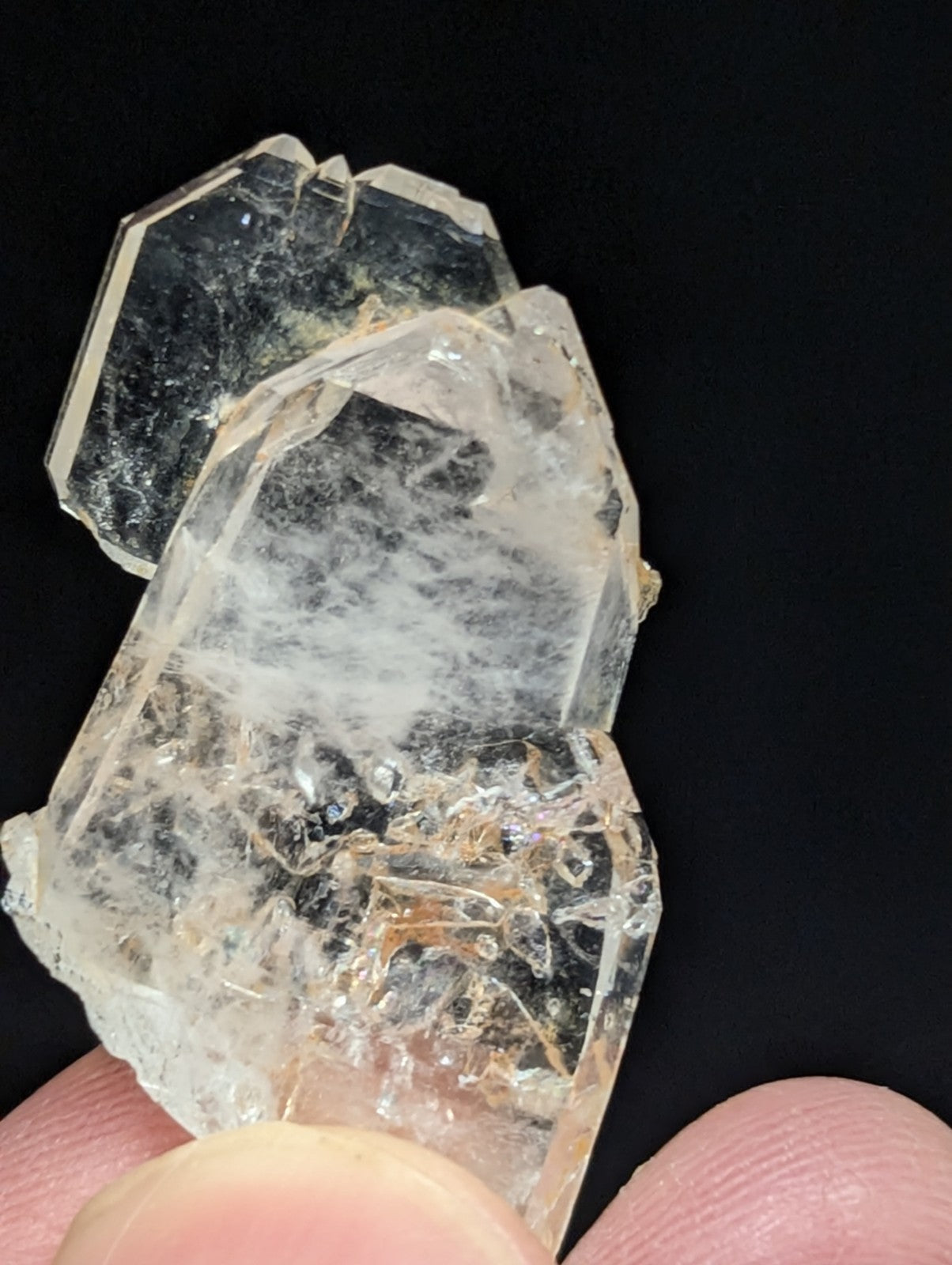 A translucent, clear quartz crystal cluster with visible internal inclusions and a rough, jagged surface.