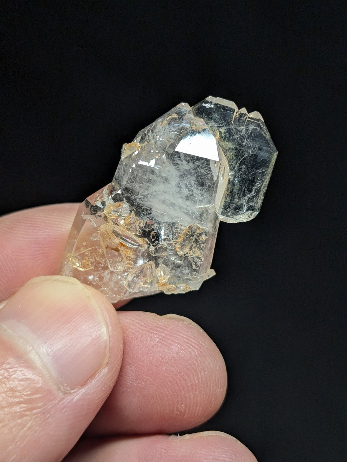 A translucent, clear quartz crystal cluster with subtle golden inclusions and sharp geometric facets.