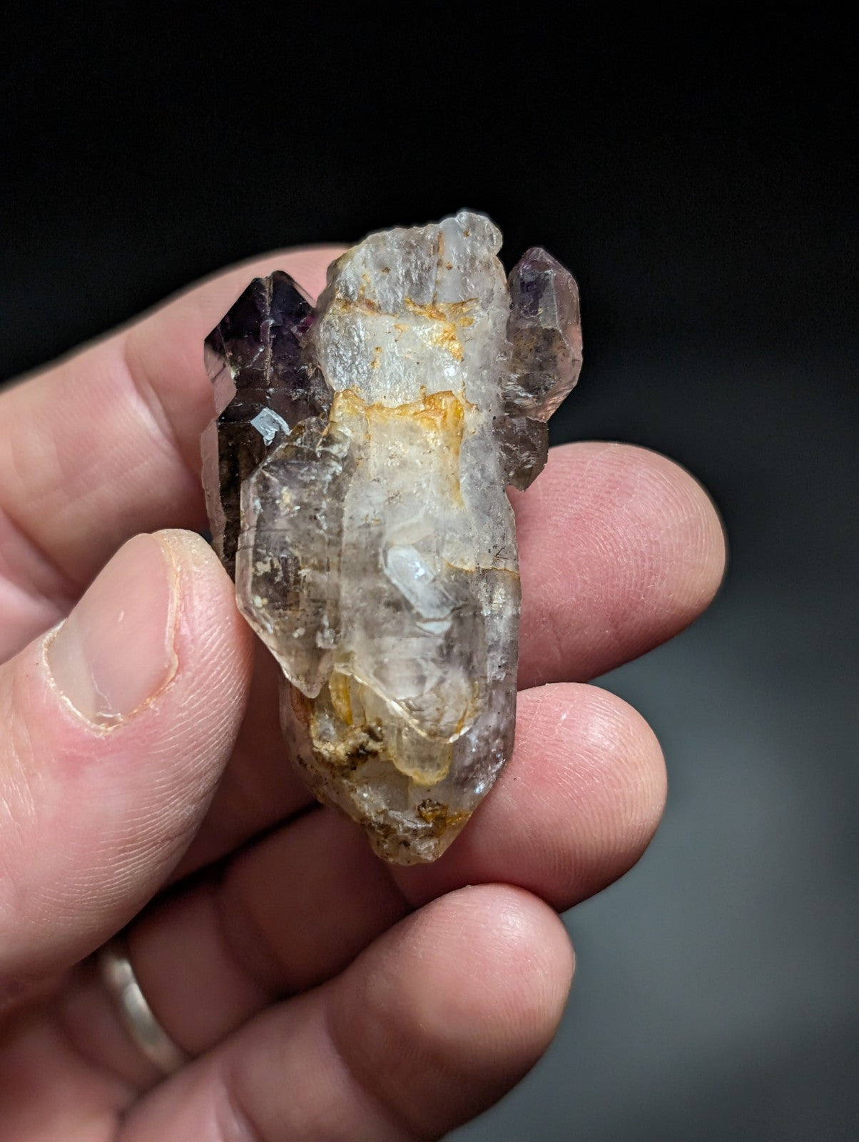A translucent, multi-faceted crystal cluster with a mix of clear and deep purple hues.