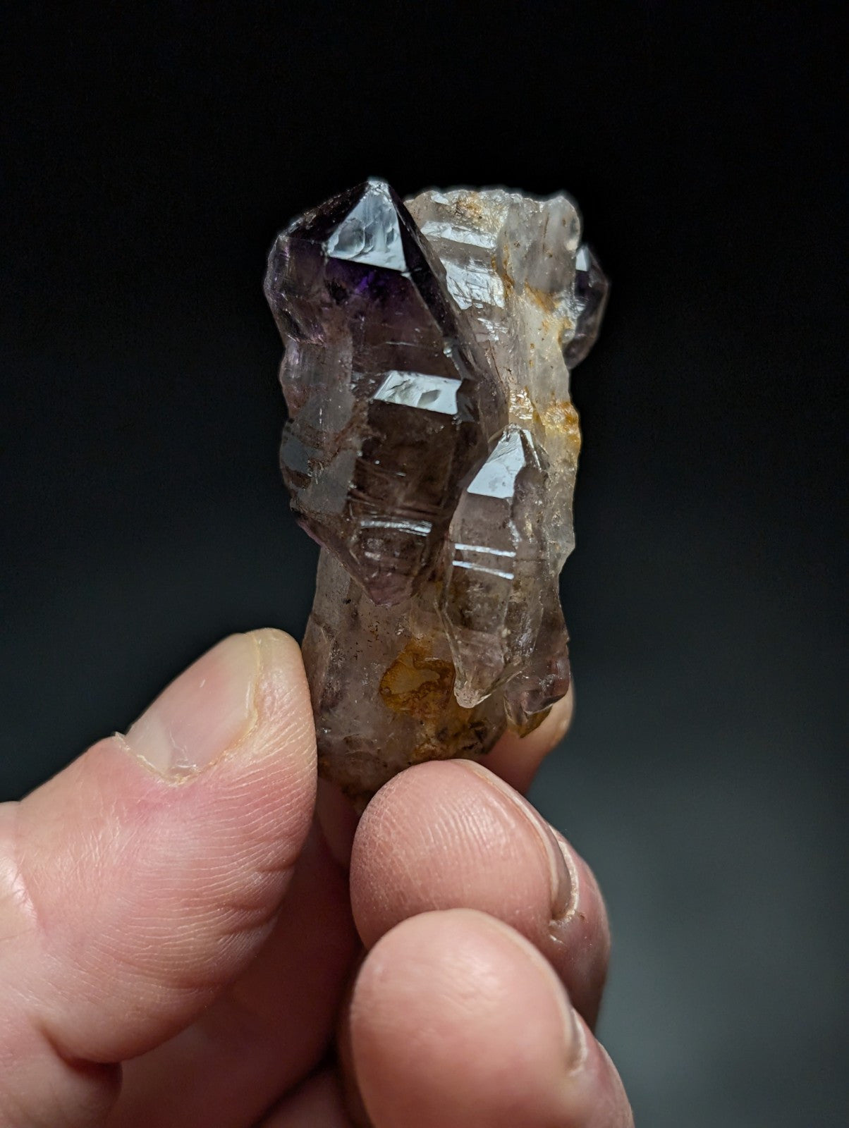 A translucent amethyst crystal cluster with sharp, faceted points and subtle purple hues.