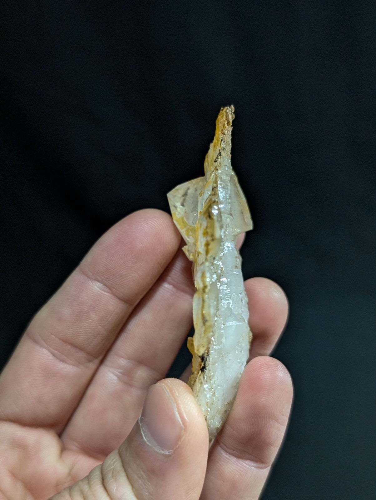 A translucent, pale yellowish-white mineral specimen with a smooth, slightly glossy surface and subtle internal striations.