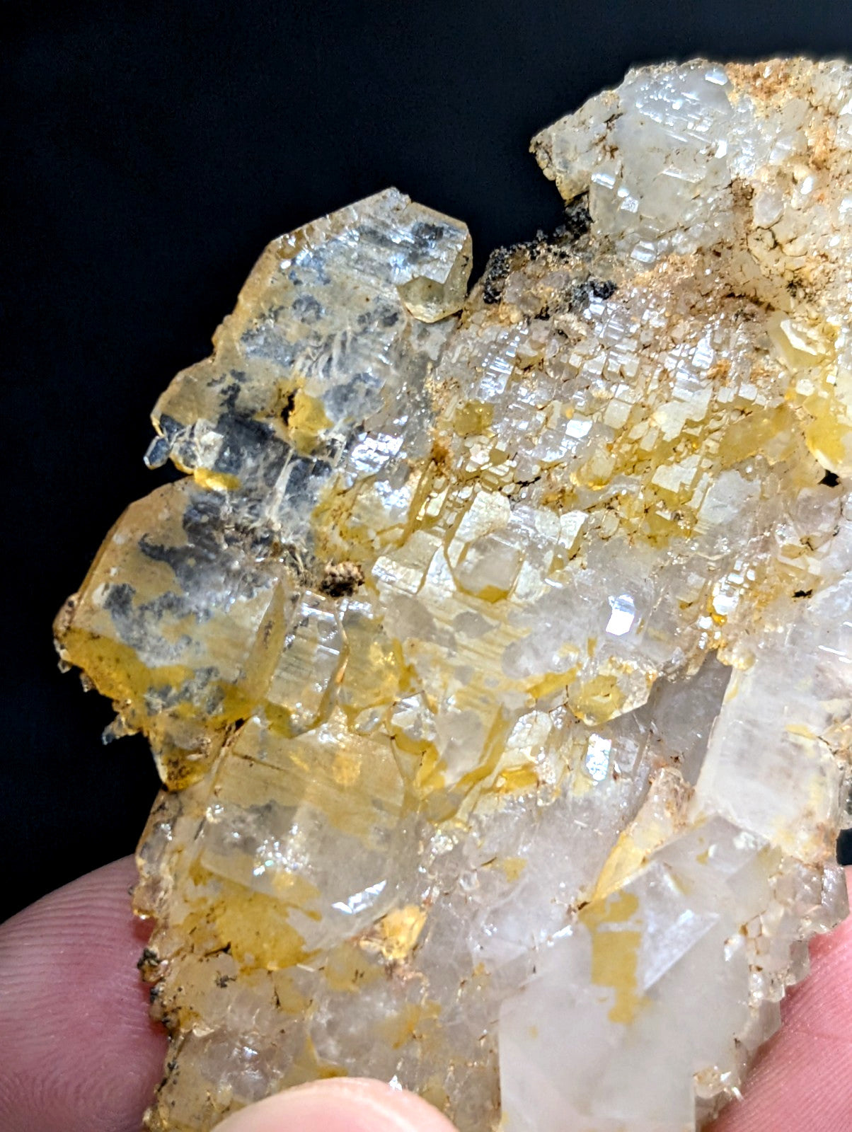 A cluster of translucent, crystalline minerals with a mix of clear and golden-yellow hues.