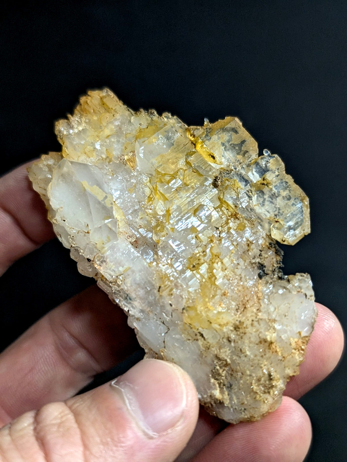 A translucent, crystalline mineral specimen with golden-yellow inclusions and a rough, jagged surface.