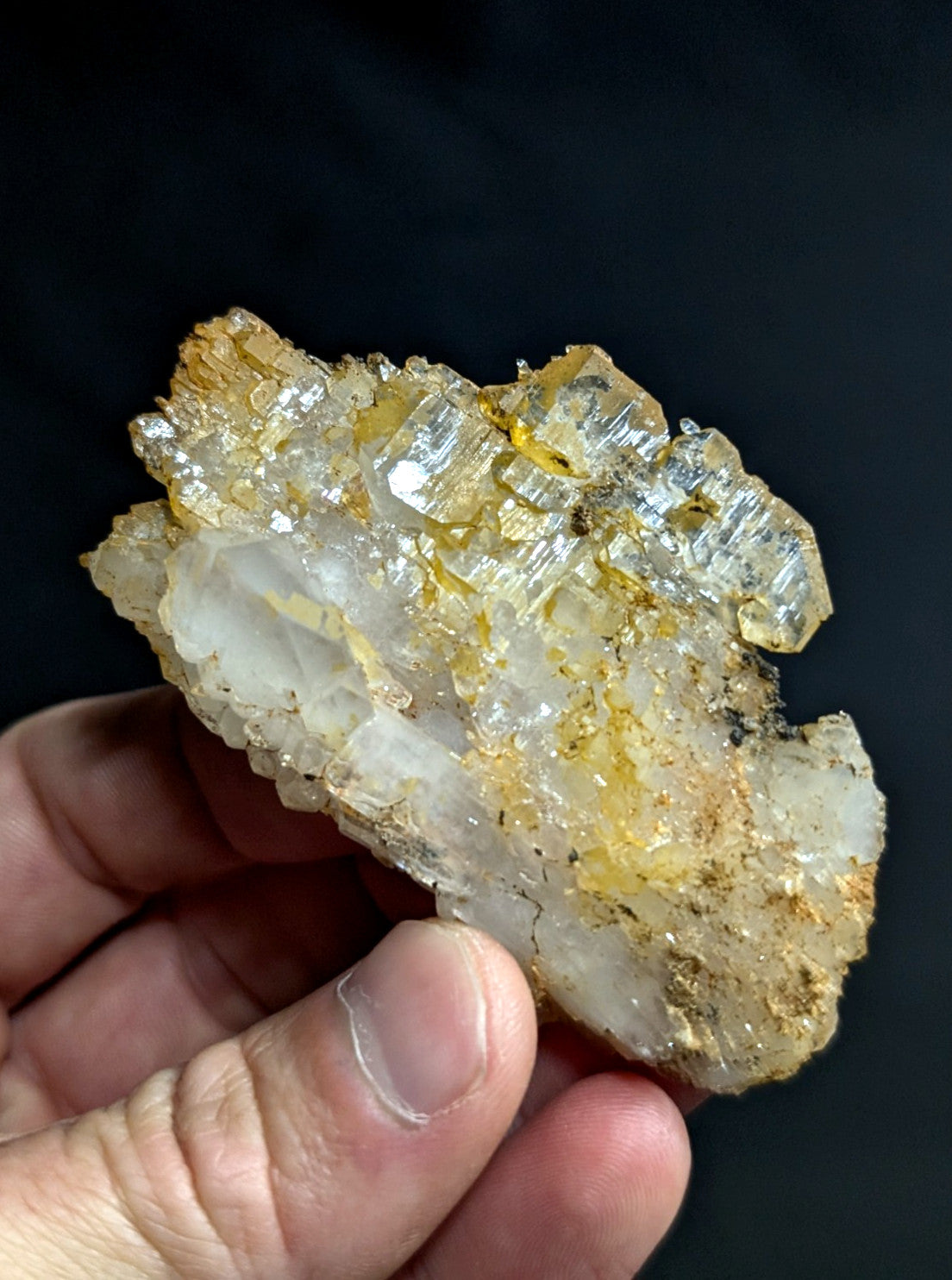 A translucent, crystalline mineral specimen with golden-yellow inclusions and a rough, jagged surface.