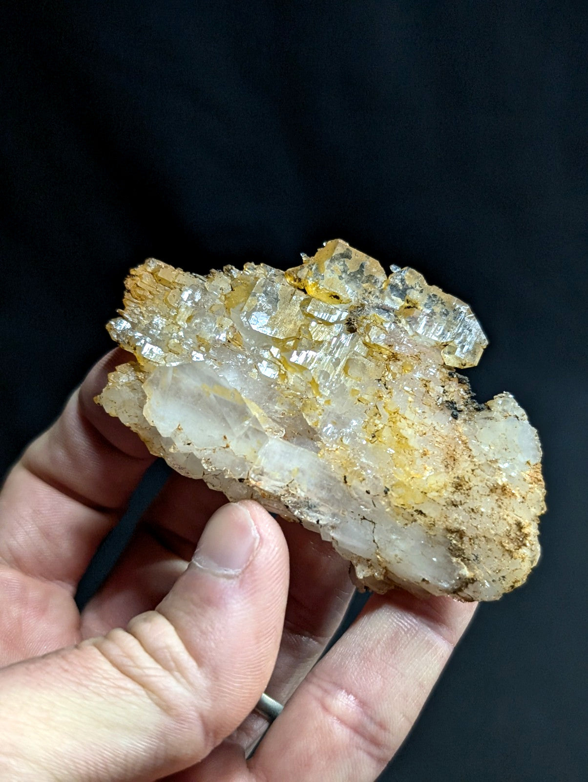 A translucent, crystalline mineral specimen with golden-yellow matrix and clear quartz crystals.