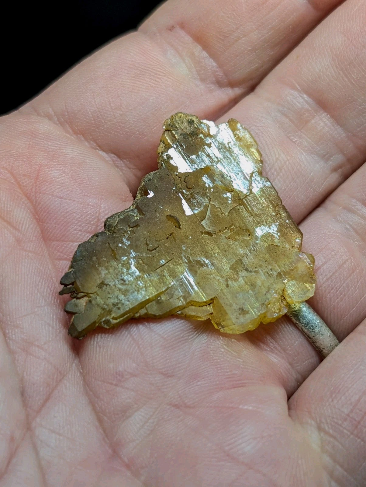 A translucent golden-yellow crystal cluster with a rough, jagged surface and visible internal striations.