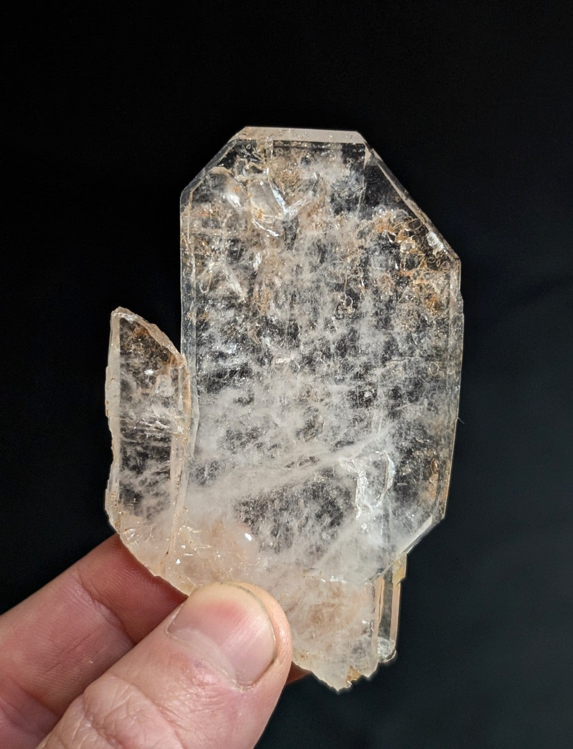 A translucent, clear quartz crystal with a rough, natural surface and visible internal inclusions.