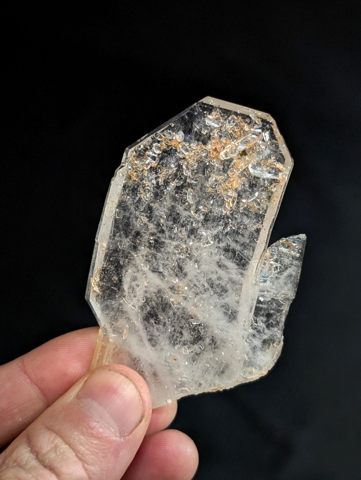 A translucent, irregularly shaped quartz crystal with visible internal inclusions and a slightly rough, faceted surface.