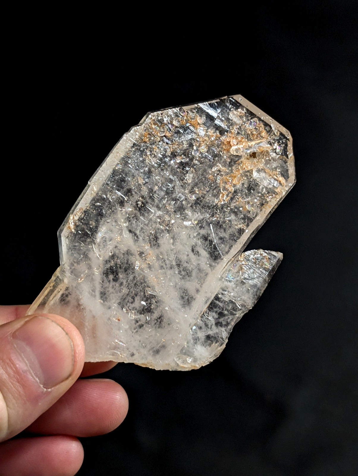 A translucent, clear quartz crystal with a rough, faceted surface and subtle internal inclusions.