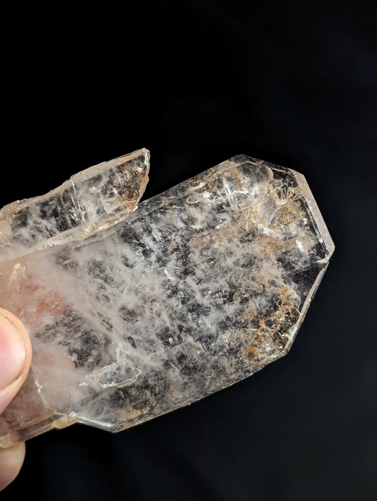 A translucent, faceted quartz crystal with natural inclusions and a slightly cloudy appearance.