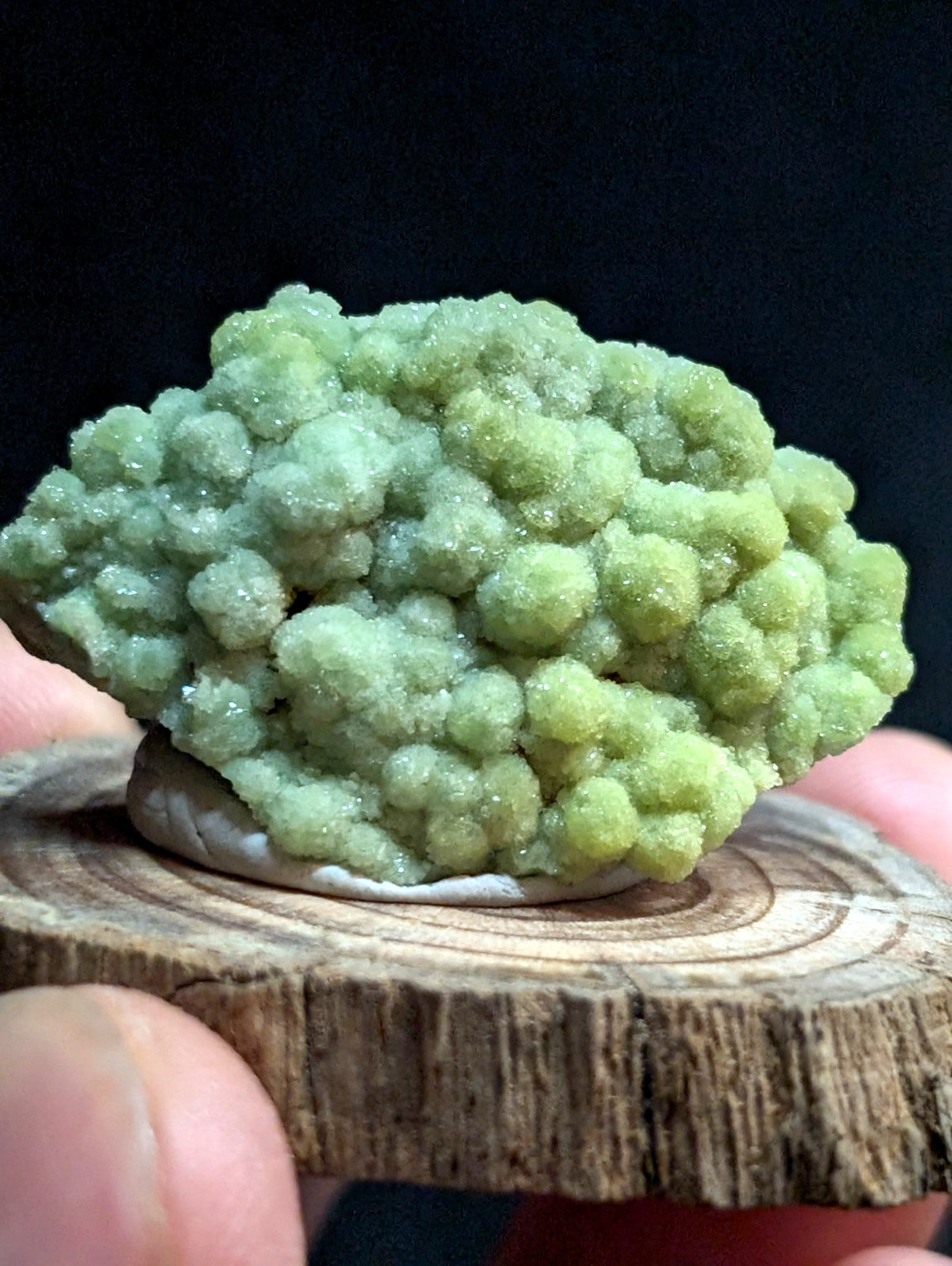 A vibrant green, crystalline mineral specimen with a textured, bumpy surface.