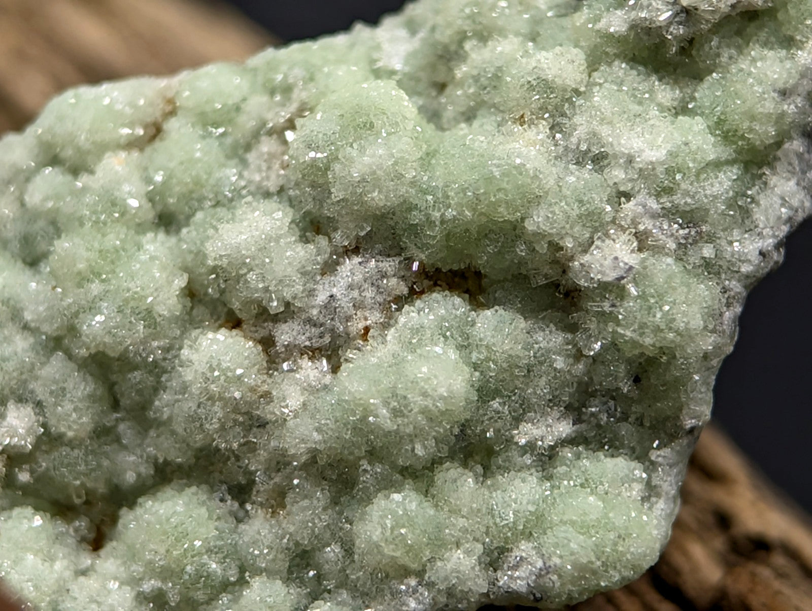 A cluster of translucent, pale green crystals with a crystalline texture and subtle white highlights.