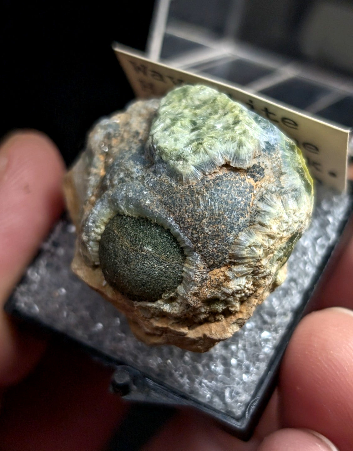 A green and gray waveite mineral specimen with a textured, layered surface.